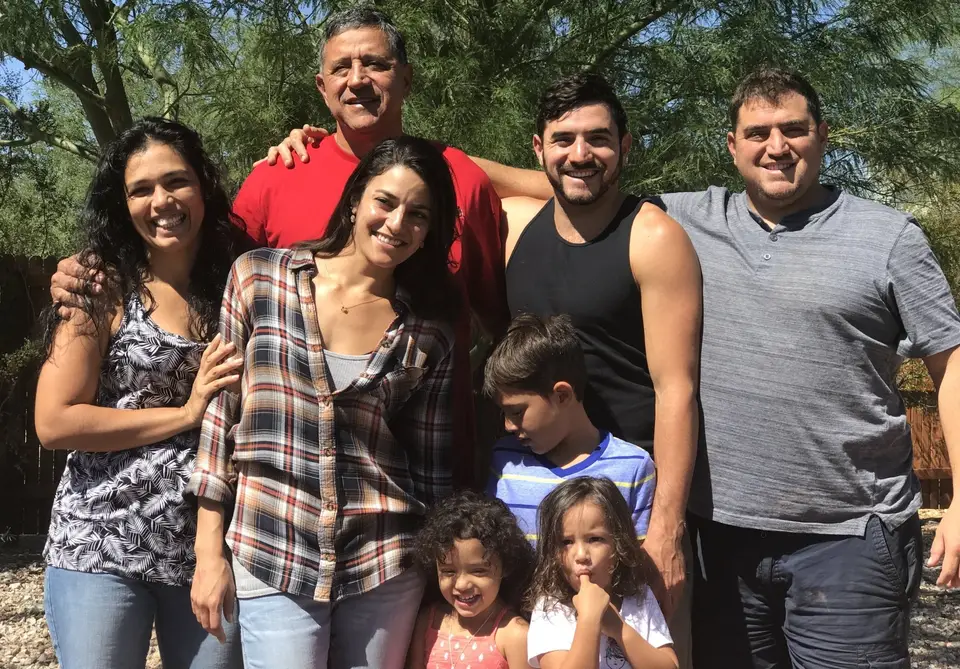 The Acedo family, owners of Villas Jacquelina, smiling together outdoors