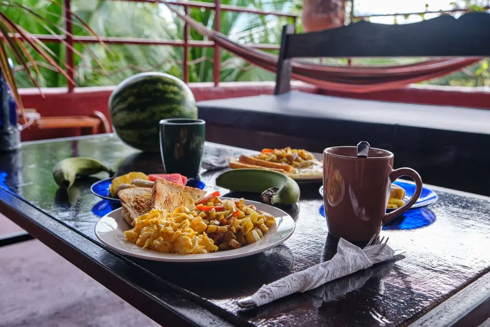 A breakfast spread with watermelon, coffee and pancakes on the red terrace table