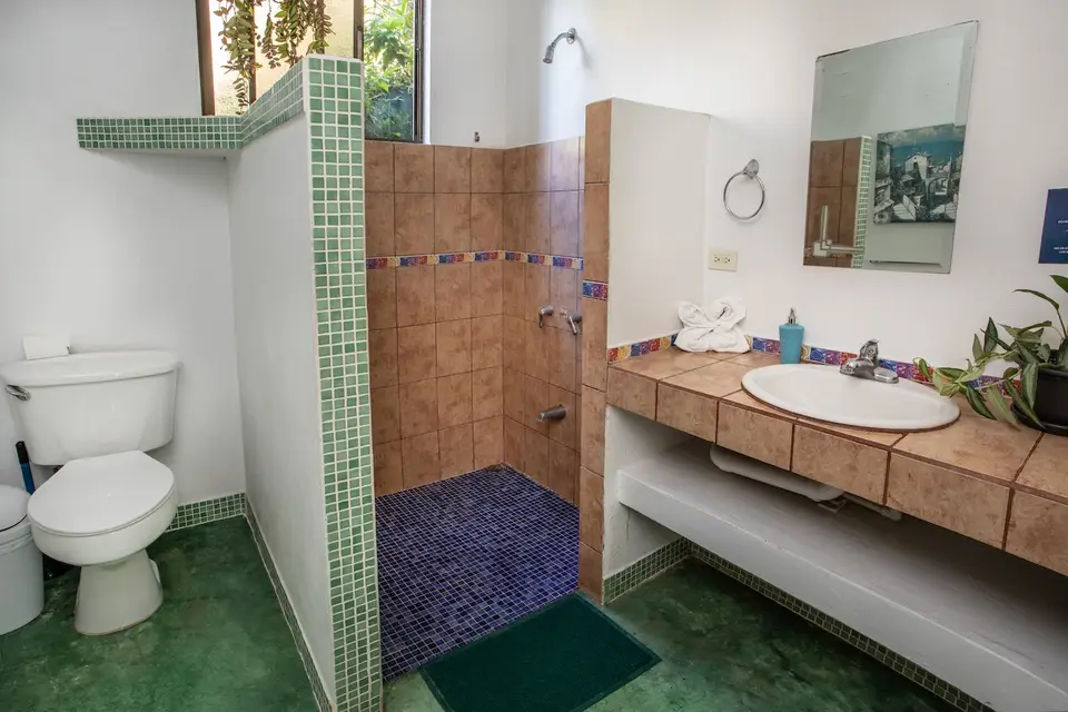 Shared bathroom near Villa Escondido: walk-in shower, wooden vanity and mirror