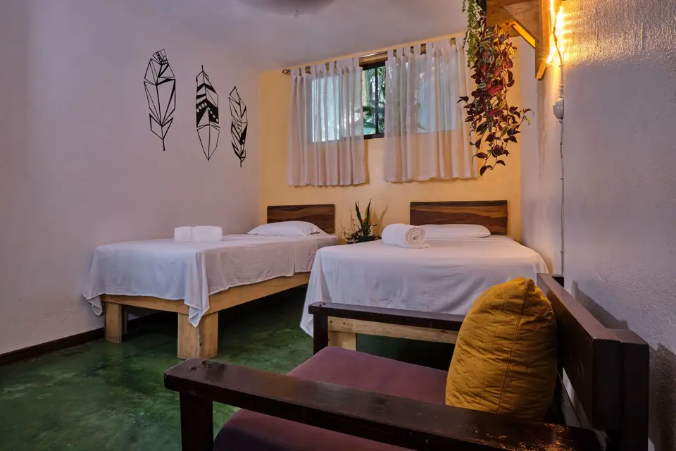 Villa Escondido: two single beds, feather wall art and an armchair with a yellow cushion