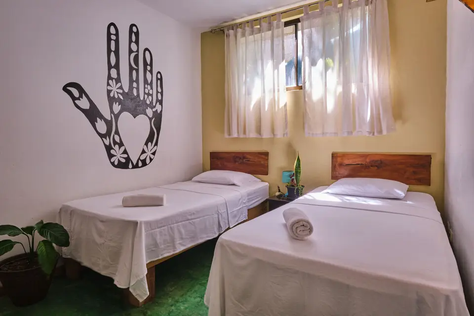 Villa Escondido: two single beds under the black hand mural