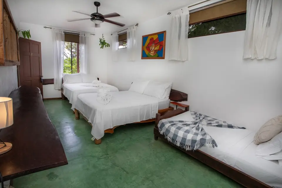 Villa Fresca (Room 9): beds under a ceiling fan, wooden window shutters