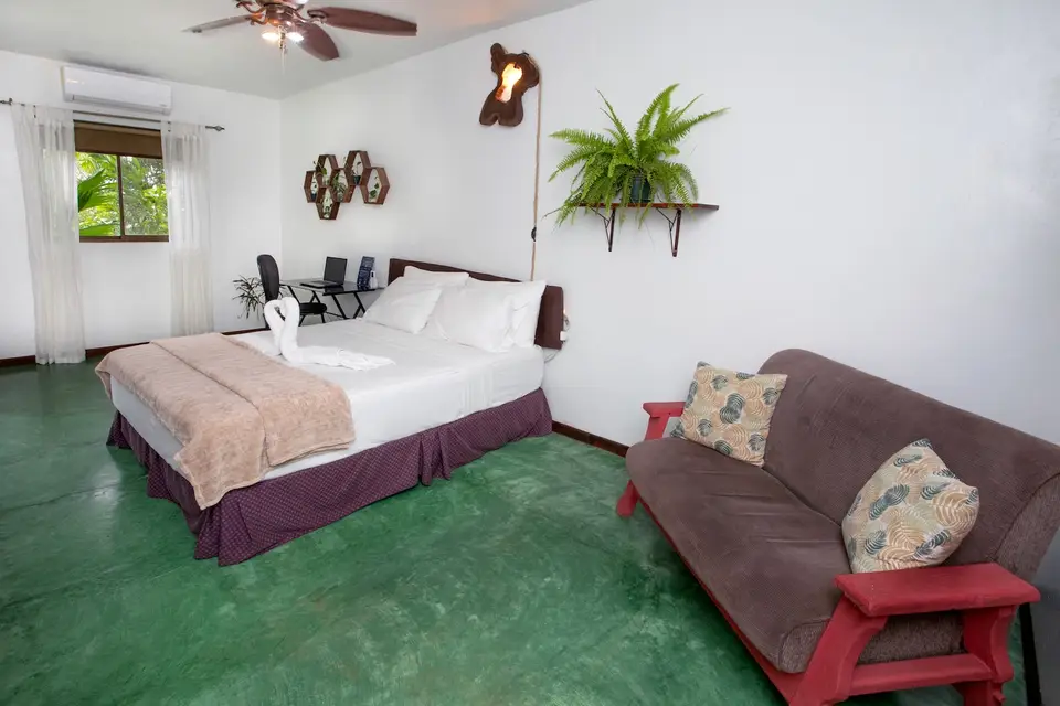 Villa Linda: queen bed and a small sofa on the green floor
