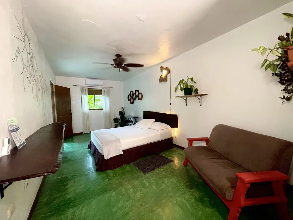 Villa Linda: the bed, a brown sofa on a red frame and a ceiling fan