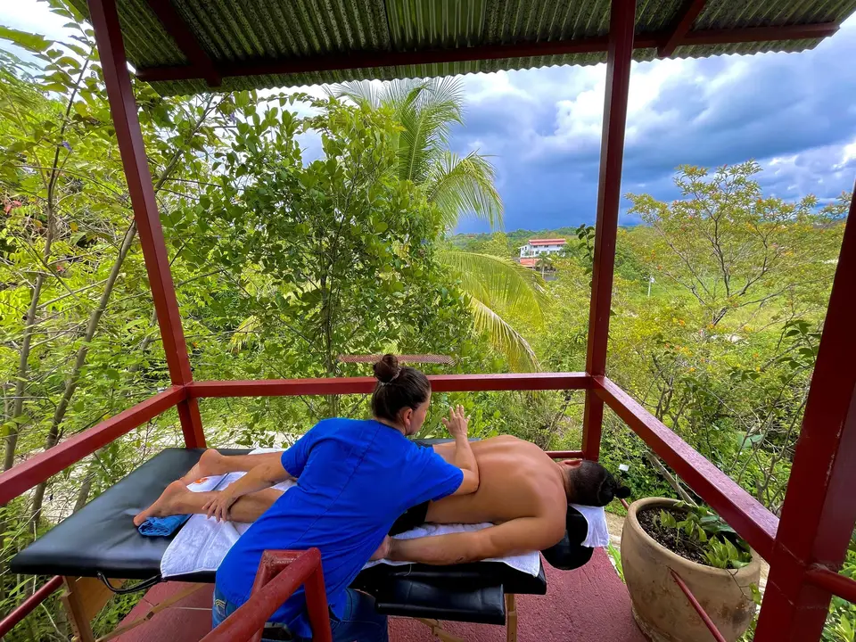 A massage on a table on the terrace, the jungle and mountains behind