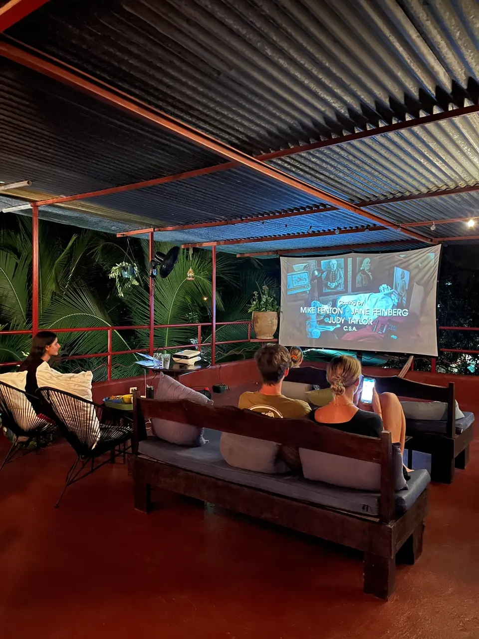 Rooftop movie night: guests on the sofas in front of the projector screen