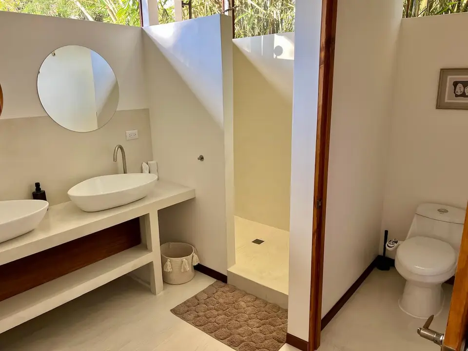 Bird’s Nest bathroom: vessel sink, round mirror and walk-in shower