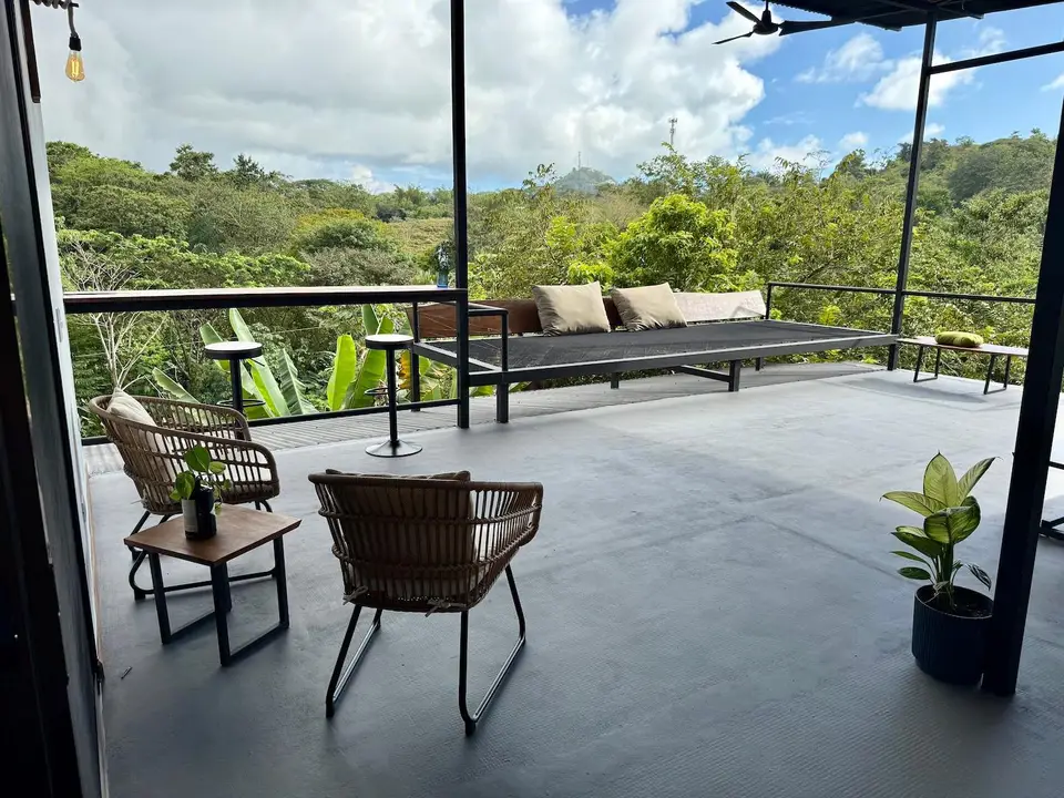 Bird’s Nest Apartment: terrace chairs and day bed looking over the valley