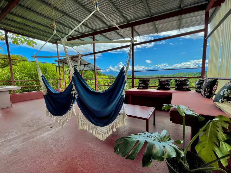 El Palomar: blue hammocks, a monstera and the valley beyond