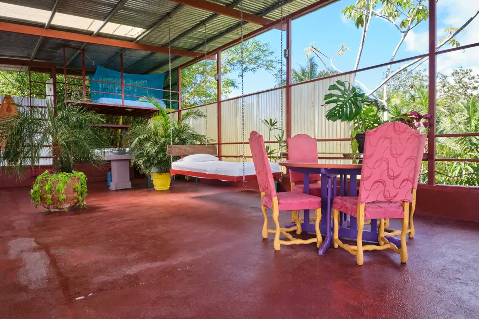 El Palomar: pink chairs around a table on the red floor