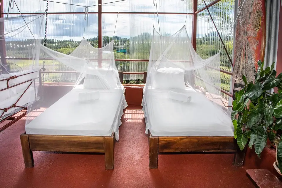 El Palomar: two single beds under mosquito nets on the open-air rooftop, with the valley beyond