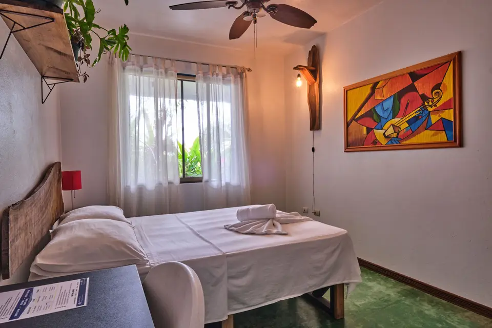 Villa Sol: una cama matrimonial, una pintura abstracta de colores y abanico de techo