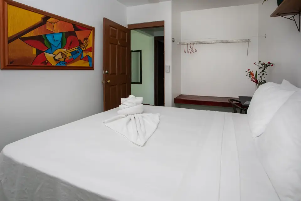 Villa Sol: cama matrimonial con toallas dobladas y una pintura colorida