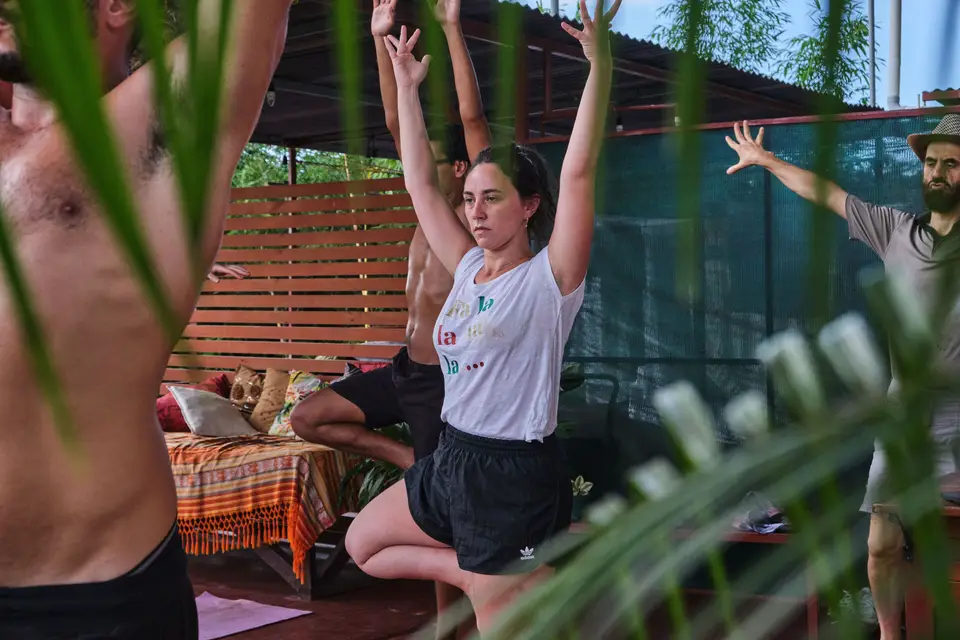 A guest stretching her arms overhead among the plants on the terrace