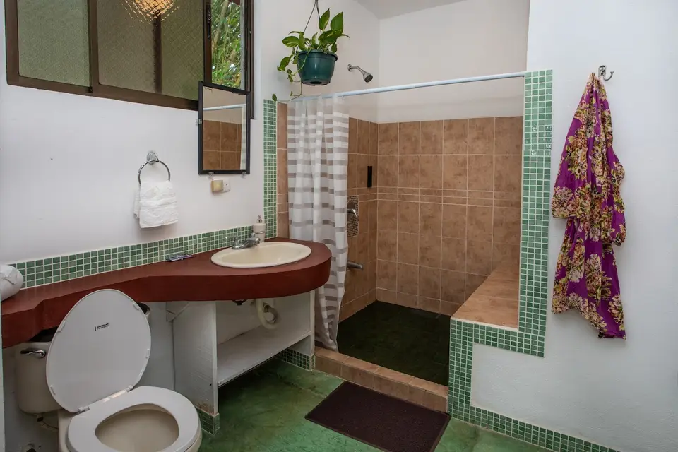 Villa Vista’s bathroom: shower, basin and a striped towel