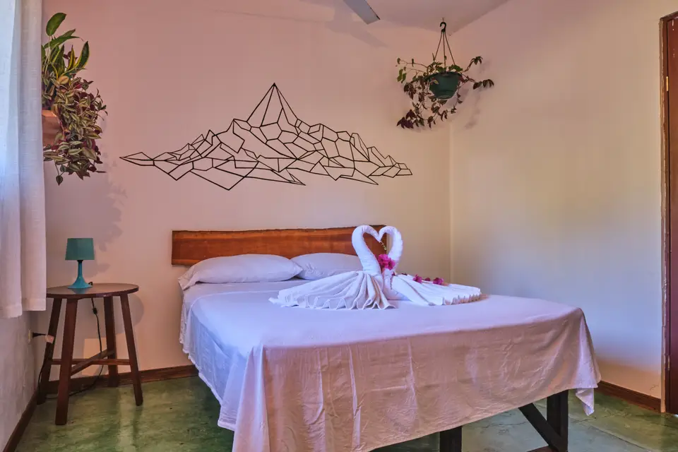 Villa Vista, bedroom two: a double bed under wire mountain art