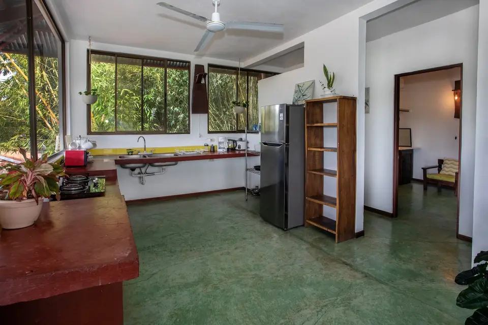 Villa Vista: kitchen and lounge with a wall of windows to the jungle
