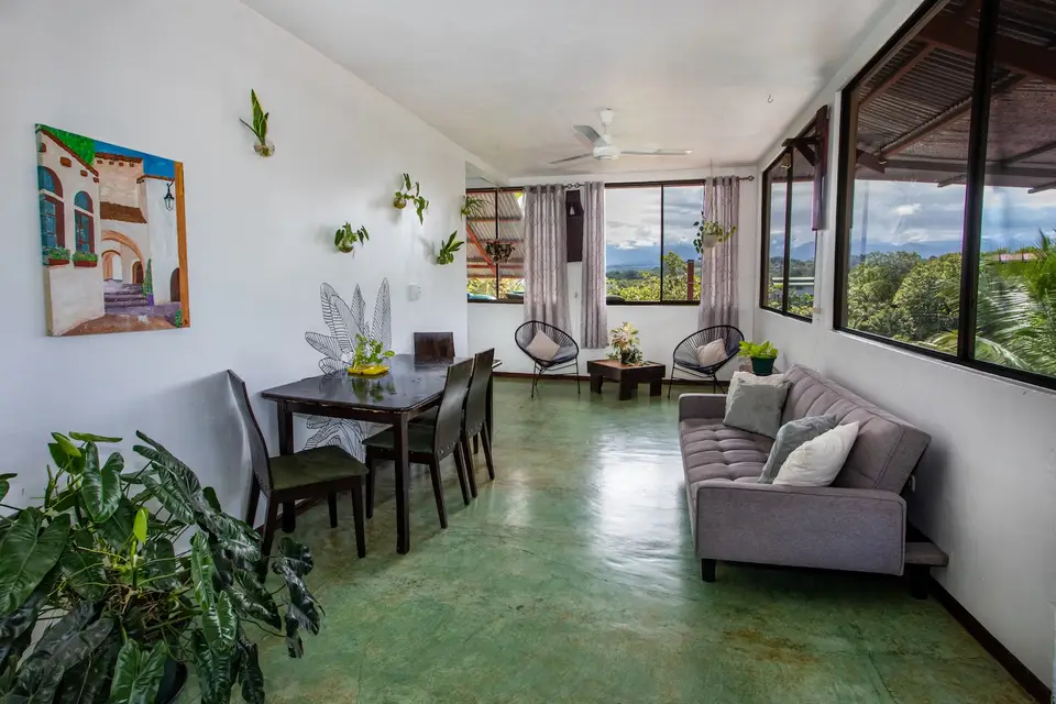 Villa Vista’s living and dining area with windows onto the treetops